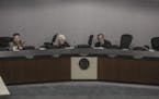 A still taken from video shows council members taking cover after a shooting at City Hall in New Hope during a City Council meeting on Monday, January
