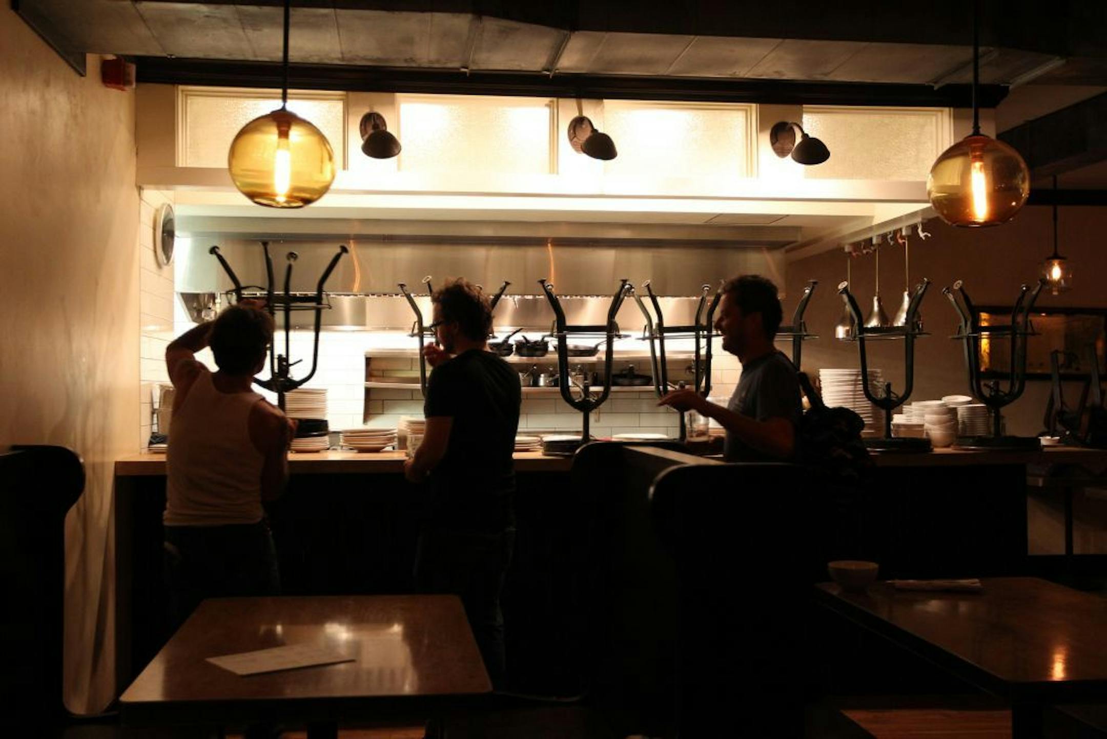 Staff members stack chairs on the open kitchen bar after closing at Tilia in Linden Hills during the first hour of August 4, 2012. 1:21 AM