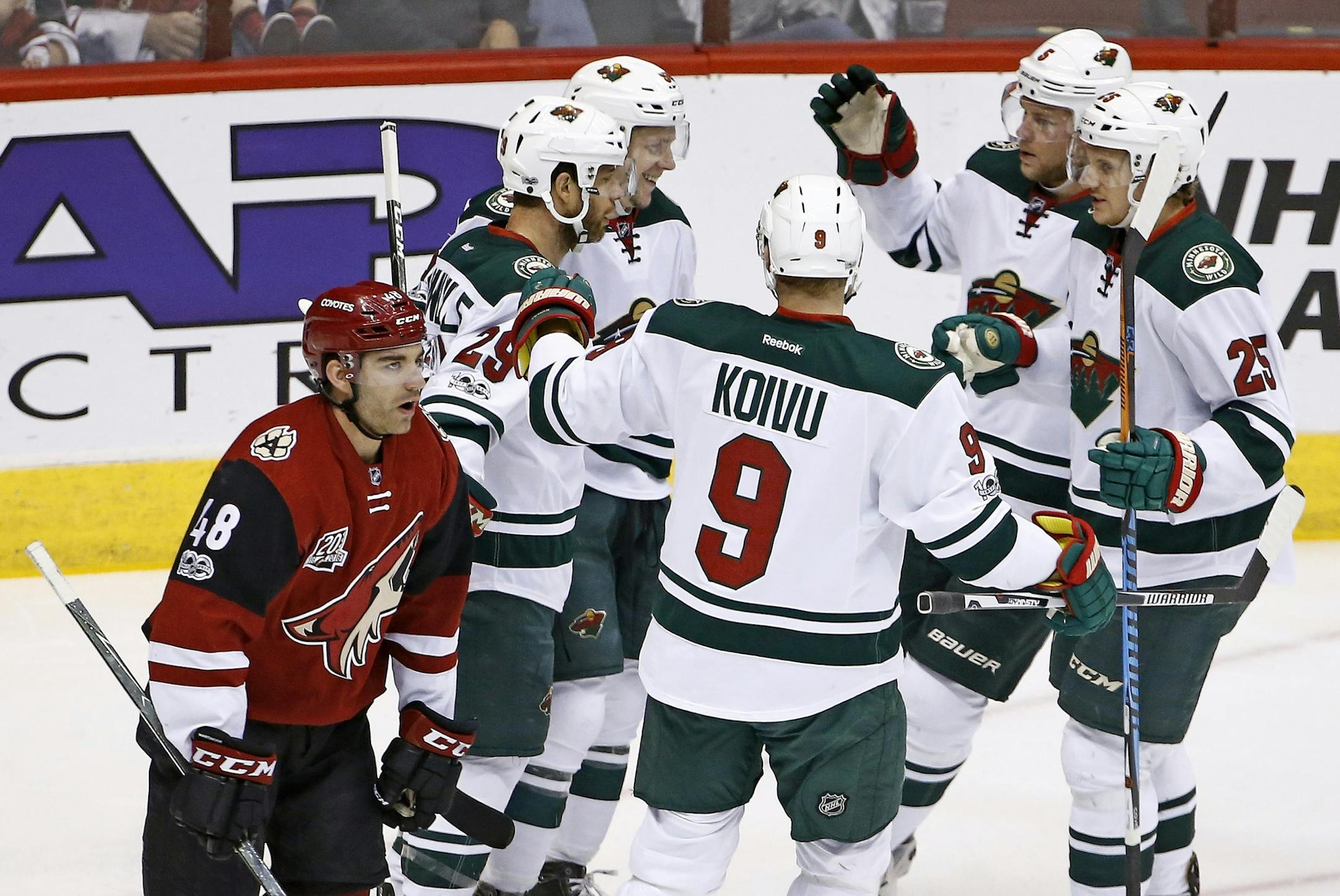 Minnesota Wild's Erik Haula celebrates his goal against the Arizona Coyotes with Jason Pominville (29), Mikko Koivu (9), Jonas Brodin (25) and Christian Folin (5) as Coyotes' Jordan Martinook (48) skates past during the first period of an NHL hockey game Saturday, April 8, 2017, in Glendale, Ariz. (AP Photo/Ross D. Franklin)