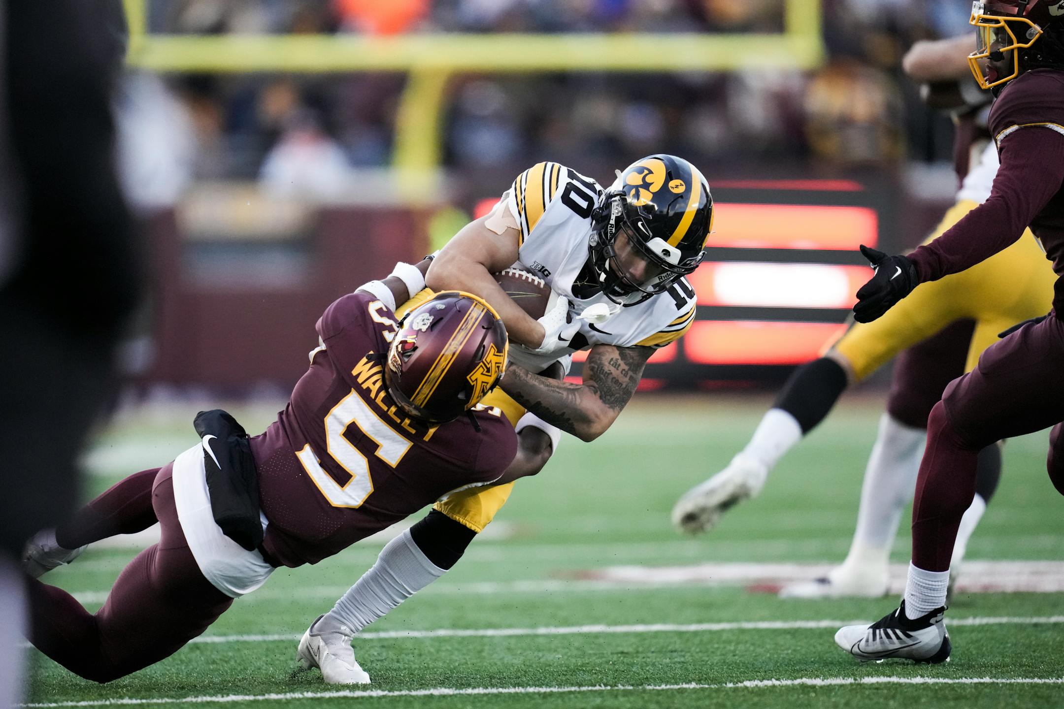 Minnesota Gophers defensive back Justin Walley (5) tackled Iowa Hawkeyes wide receiver Arland Bruce IV (10) in the second quarter.