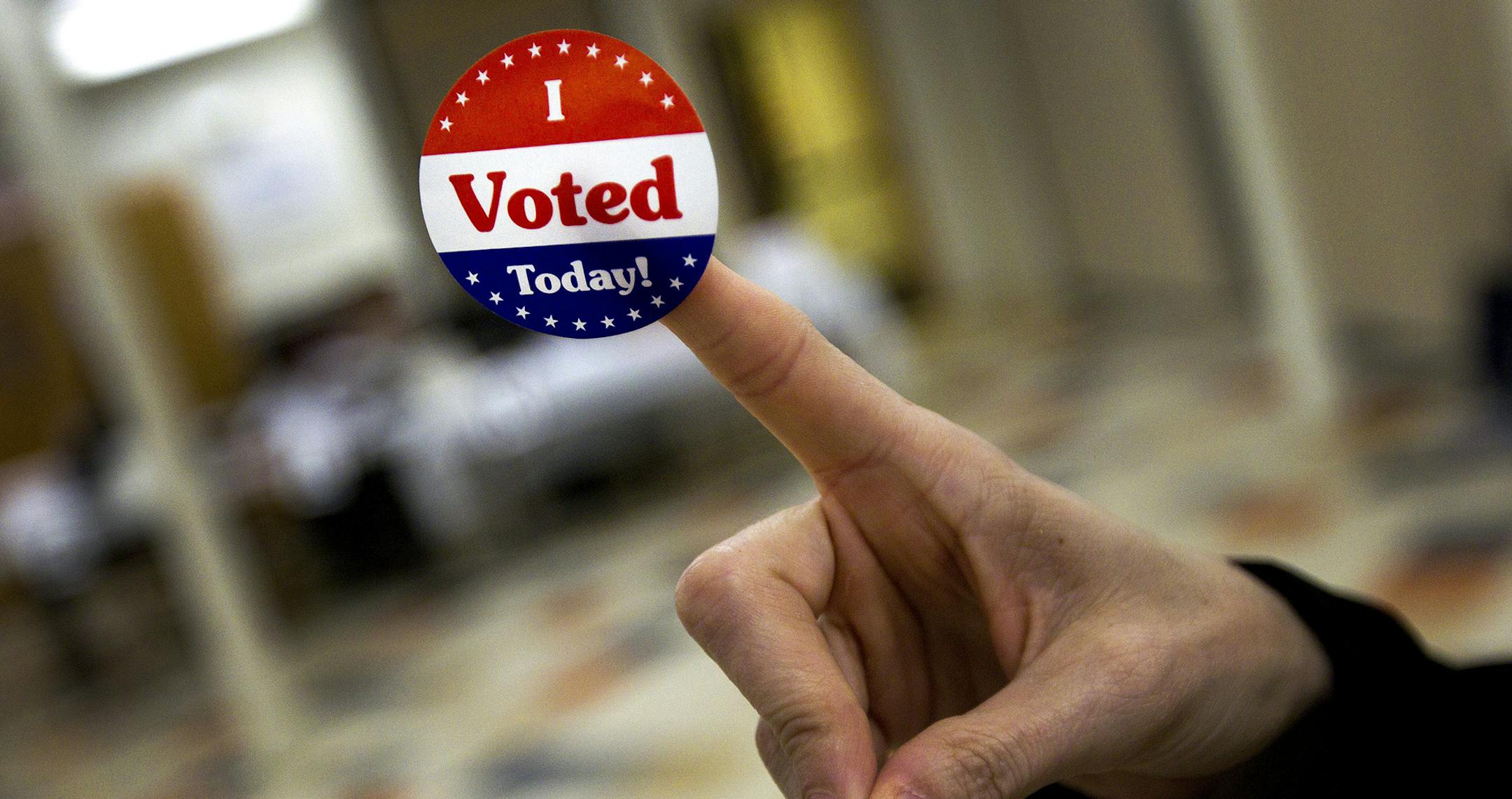 A voter displays a "I voted" sticker in a polling station at the Chinese Community Church in Washington, April 3, 2012. Voters are headed to the polls in Wisconsin, Maryland and Washington Tuesday to continue the narrowing of the field in the Republican presidential nominating contest. (Doug Mills/The New York Times) ORG XMIT: MIN2012103114204975 ORG XMIT: MIN1605270022560612
