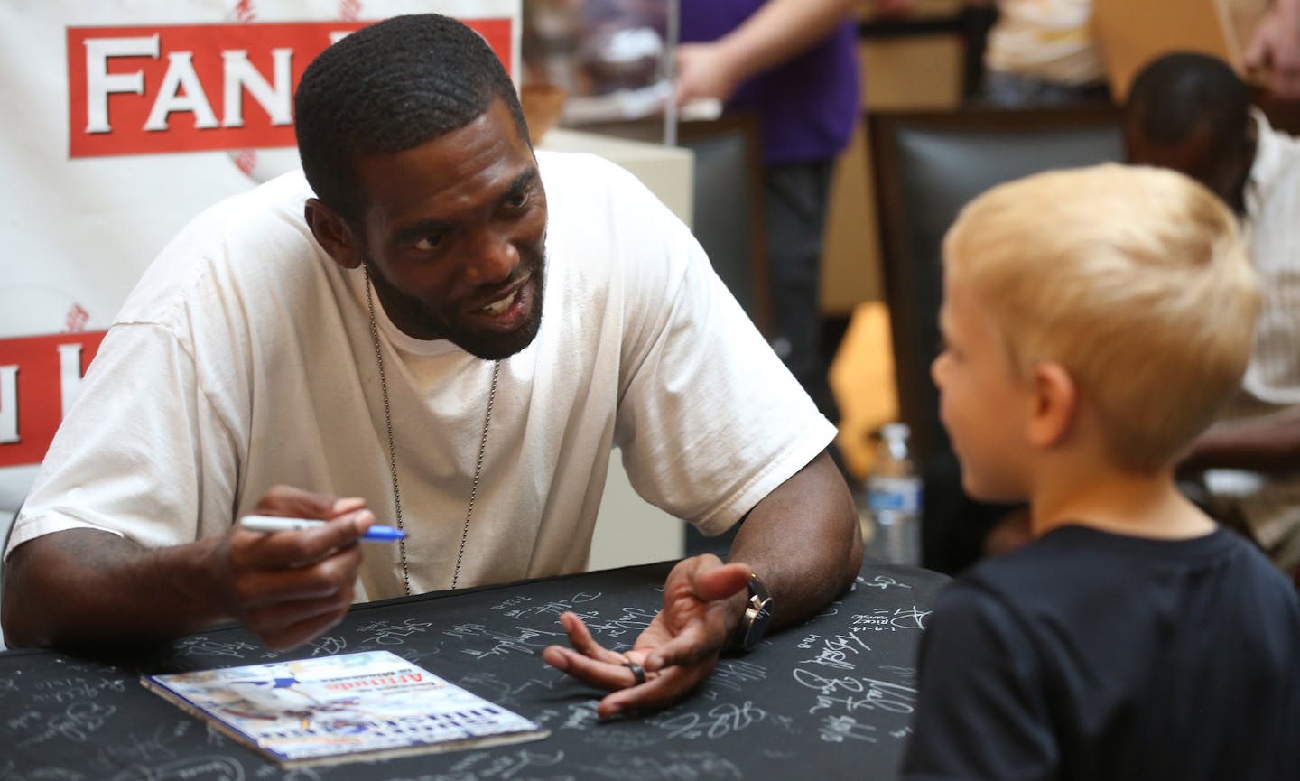 Former Viking Randy Moss tried to get Caden Schaefer, 5, to tell him his name during an autograph event. ] (KYNDELL HARKNESS/STAR TRIBUNE) kyndell.harkness@startribune.com Former Minnesota Viking Randy Moss and Tyrone Cater signed autographs at the Ridgedale Mall in Minnetonka Min., Saturday, May 23, 2015. Ticket purchases benefit Tyrone Carter&#xed;s TC Elite Training School and will allow financially challenged Minnesota athletes the opportunity to attend Carter&#xed;s intensive football camps