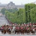 A motorcade escorting French President Francois Hollande rides up the Champs Elysees in Paris Thursday May 8, 2014, before a ceremony at the Arc de Tr