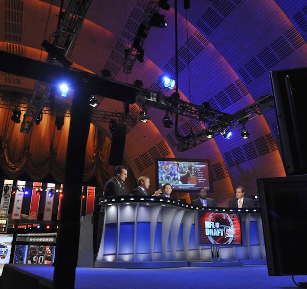FILE-- ESPN sports analysts talk before the start of The NFL Draft at Radio City Music Hall in New York, April 22, 2010. By first allowing spectators 