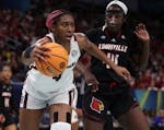 South Carolina forward Aliyah Boston (4) worked against Louisville’s Olivia Cochran in Friday’s first semifinal at Target Center.