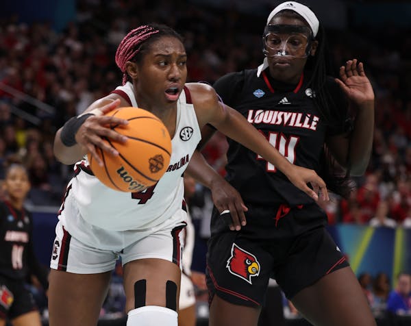 South Carolina forward Aliyah Boston (4) worked against Louisville’s Olivia Cochran in Friday’s first semifinal at Target Center.