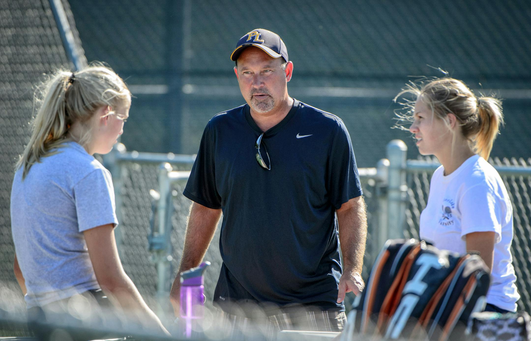 Grayce Peterson, left and (No. 4 singles) Chloe Hall, right, (No. 2 singles) talk with coach PJ Priest. ] GLEN STUBBE * gstubbe@startribune.com Monday September 21, 2015 Prior Lake girls' tennis practice