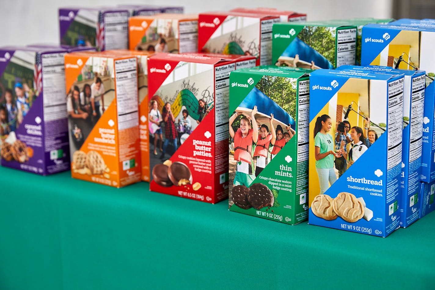 An array of Girl Scout cookie boxes lined up on a table.