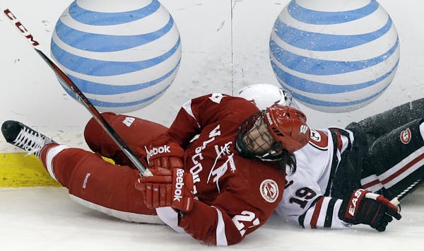 St. Cloud State's Drew LeBlanc, right, and Wisconsin's Frankie Simonelli collide along the boards in the first period of a WCHA Final Five semi-finals
