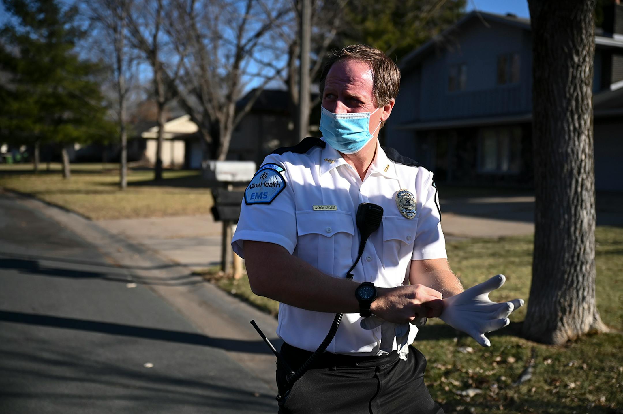Andrew Stevens, an emergency physician with Allina Health, put on gloves before treating a possible COVID-19 patient at their home in the north Metro Wednesday morning. ] AARON LAVINSKY • aaron.lavinsky@startribune.com Emergency medical workers and physician Andrew Stevens responded to possible COVID-19 related calls on Wednesday, Dec. 2, 2020 in the north Twin Cities metro.