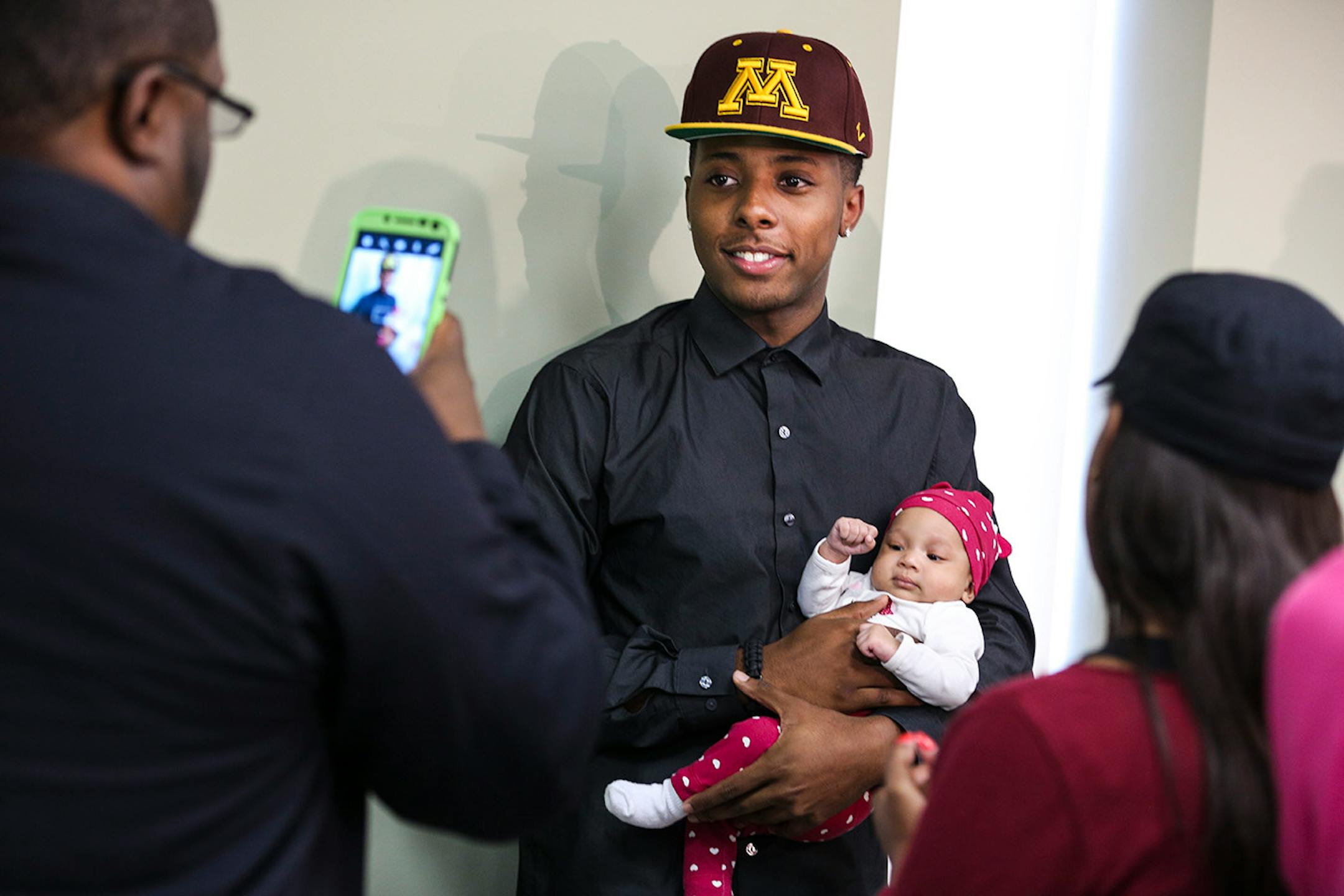 Jarvis Johnson, DeLaSalle basketball star, held a baby for a picture after he announced his college choice of the University of Minnesota at DeLaSalle High School on Friday, Sept. 12, 2014, in Minneapolis, Minn. RENEE JONES SCHNEIDER • reneejones@startribune.com