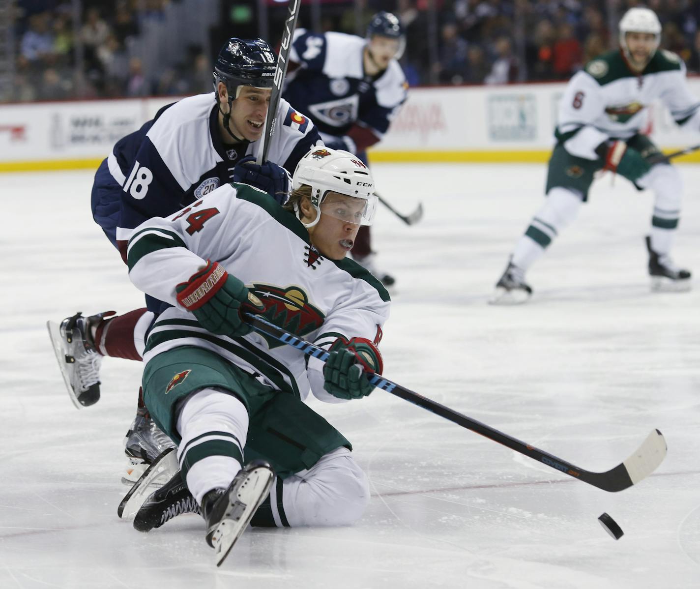 Minnesota Wild center Mikael Granlund, front, of Finland, tries to take a shot as Colorado Avalanche center Shawn Matthias defends in the third period of an NHL hockey game Saturday, March 26, 2016, in Denver. The Wild won 4-0. (AP Photo/David Zalubowski)