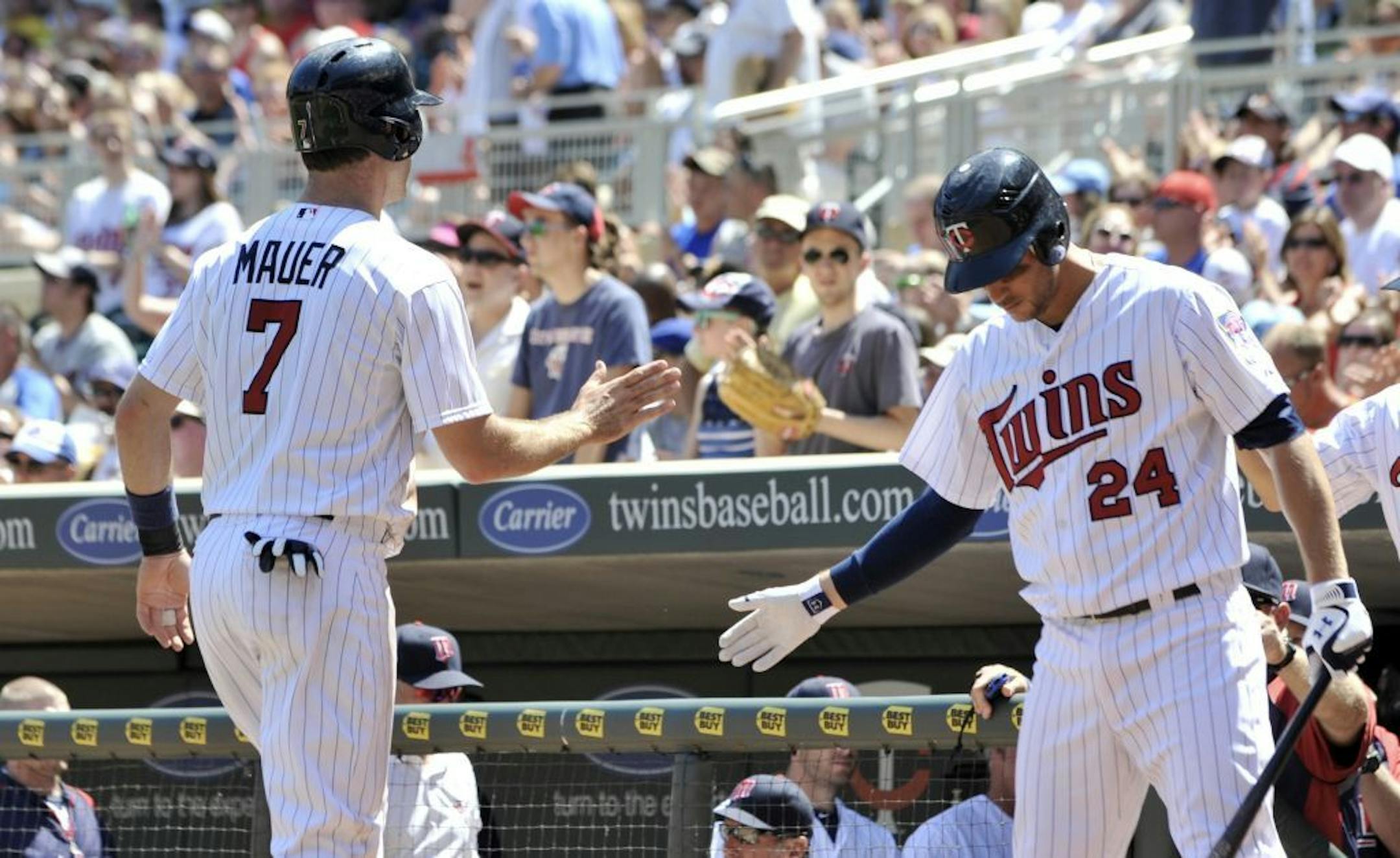Trevor Plouffe, right, welcomed Joe Mauer back to the dugout after Mauer scored on a double by Ryan Doumit in the fourth inning of the Twins' 11-3 victory over the Chicago Cubs on Saturday.