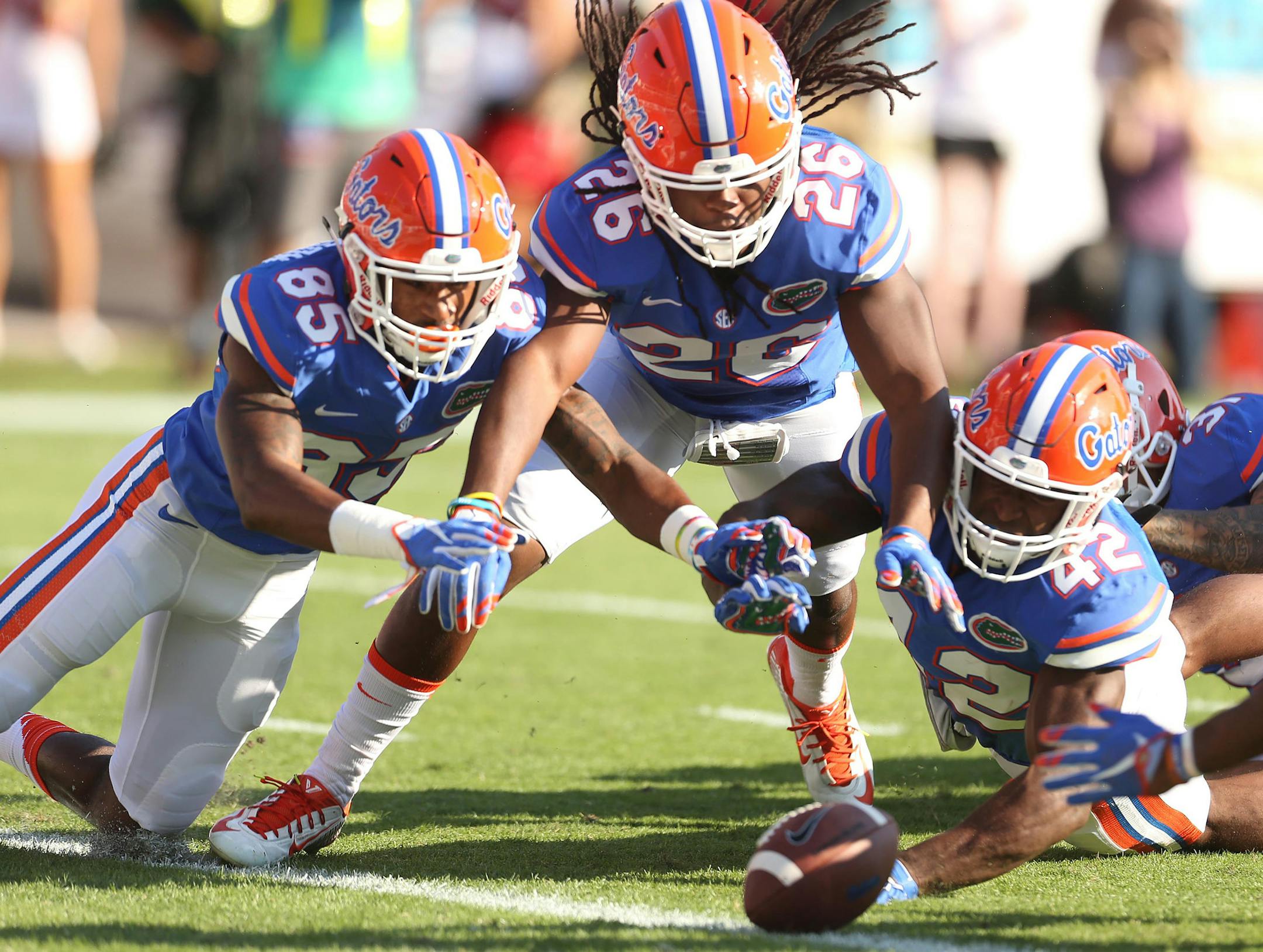 Florida's Chris Thompson (85), Marcell Harris (26), and Keanu Neal (42) leap for a fumbled punt by Georgia, leading to a touchdown for the Gators, at EverBank Field in Jacksonville, Fla., on Saturday, Oct. 31, 2015. (Stephen M. Dowell/Orlando Sentinel/TNS)