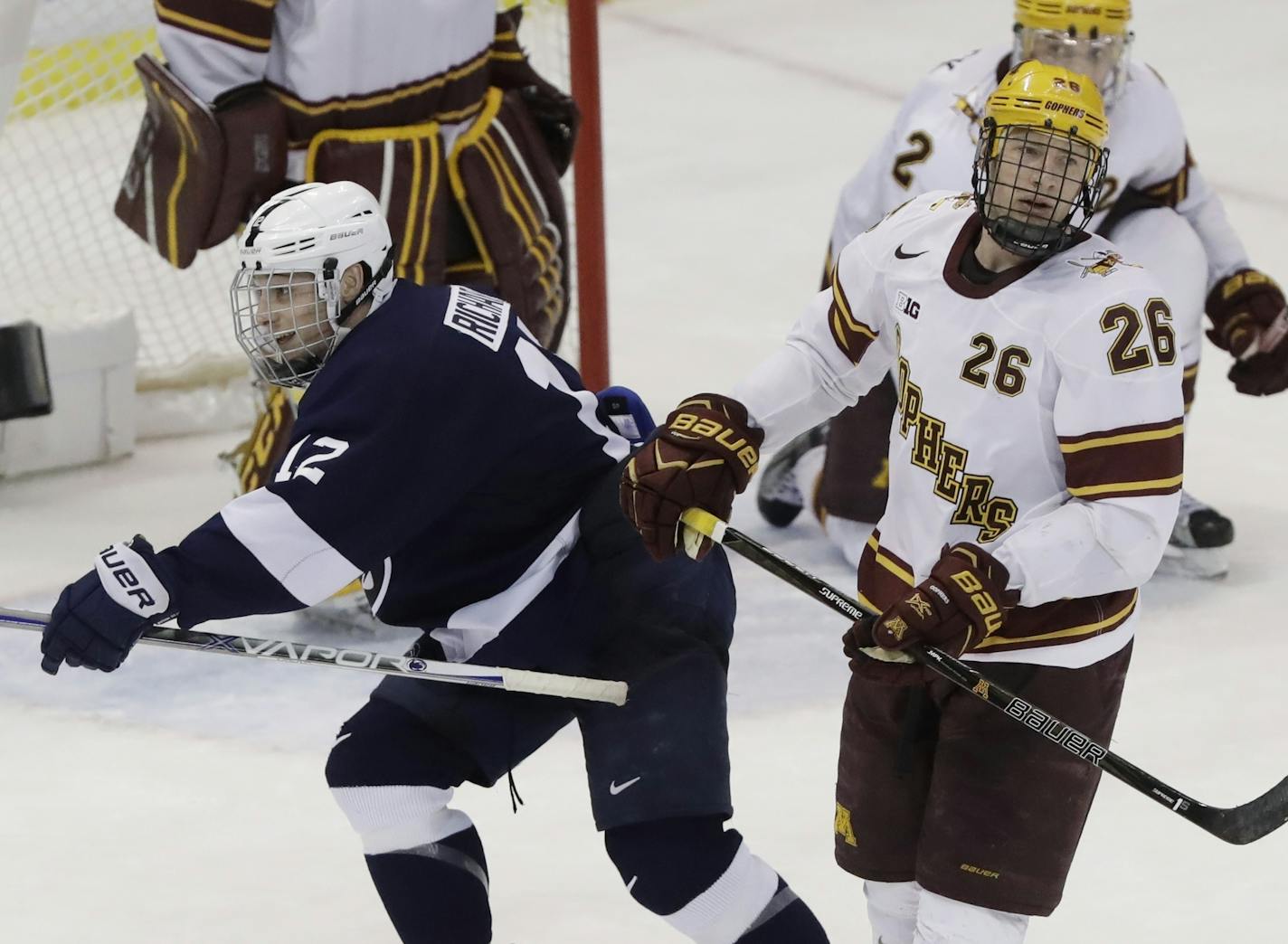 Penn State forward Dylan Richard (12) and Minnesota forward Darian Romanko (26) react after Penn State defenseman Erik Autio scored the winning goal during the second overtime of an NCAA college hockey semifinal in the Big Ten tournament, Friday, March 17, 2017, in Detroit. Penn State defeated Minnesota 4-3. (AP Photo/Carlos Osorio)