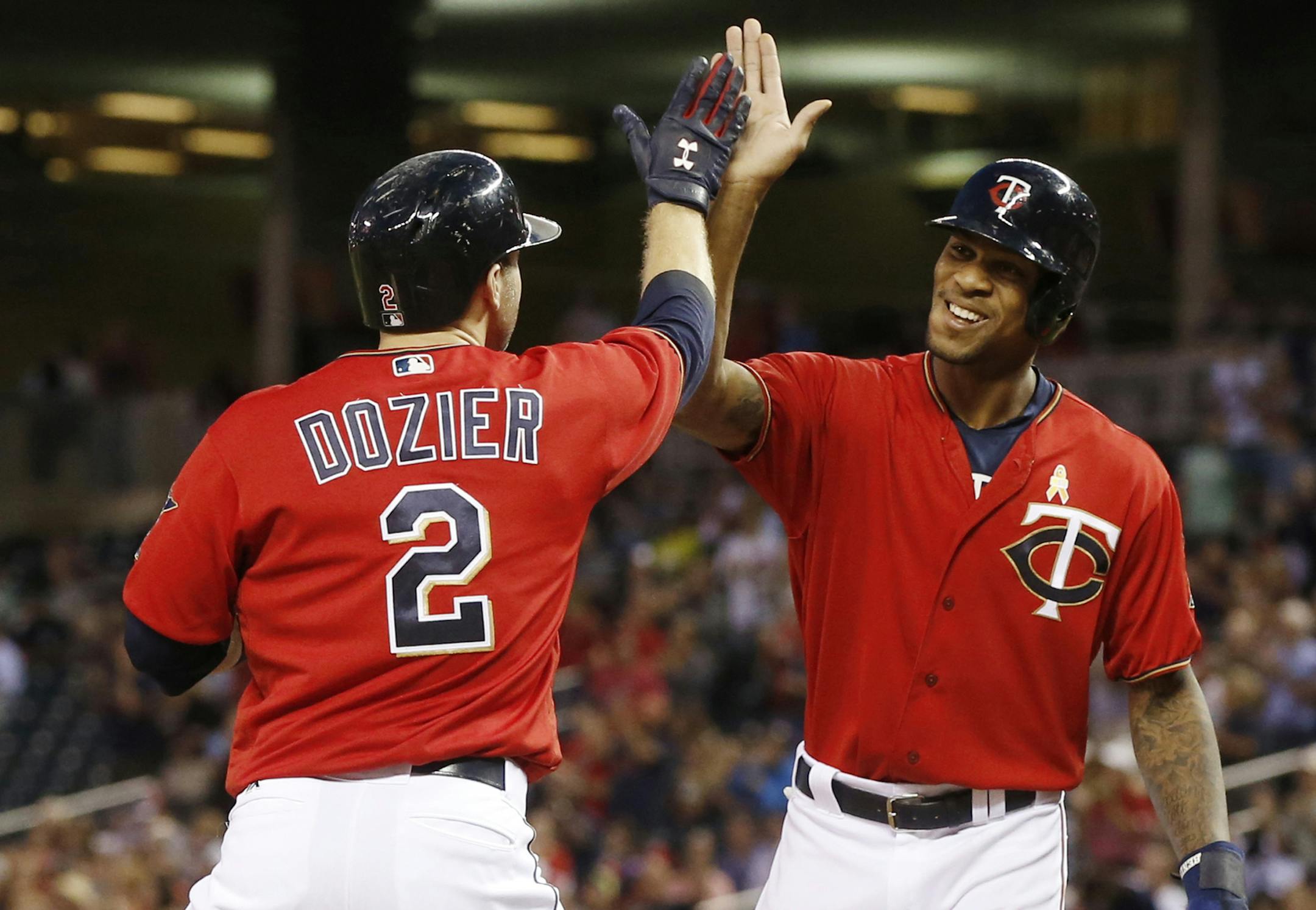 Minnesota Twins' Byron Buxton, right, high-fives Brian Dozier after Dozier's three-run home run off Chicago White Sox pitcher Carlos Rodon in the third inning of a baseball game Friday, Sept. 2, 2016, in Minneapolis. (AP Photo/Jim Mone)