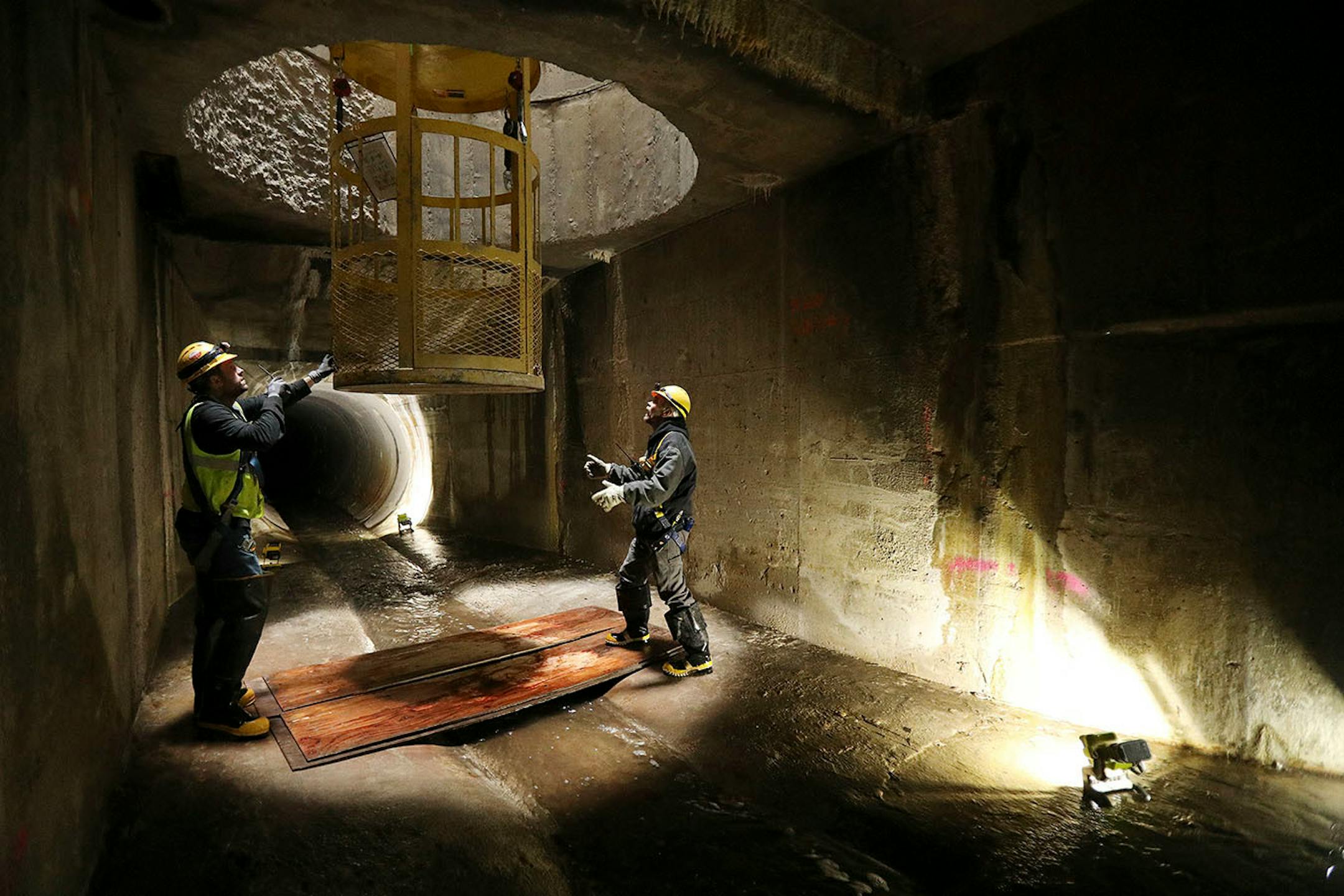 Sean Oberg , supervisor for sewer maintenance, and Danny Rohloff, construction management coordinator, readied a basket that serves as the only entry and exit point underground following a tour of Minneapolis' storm sewers in the northeast.
