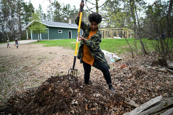 Jovan C. Speller uses a pitchfork to turn a compost pile Thursday, May 19, 2022 in Osage, Minn.. Speller moved her family and her artistic practice to