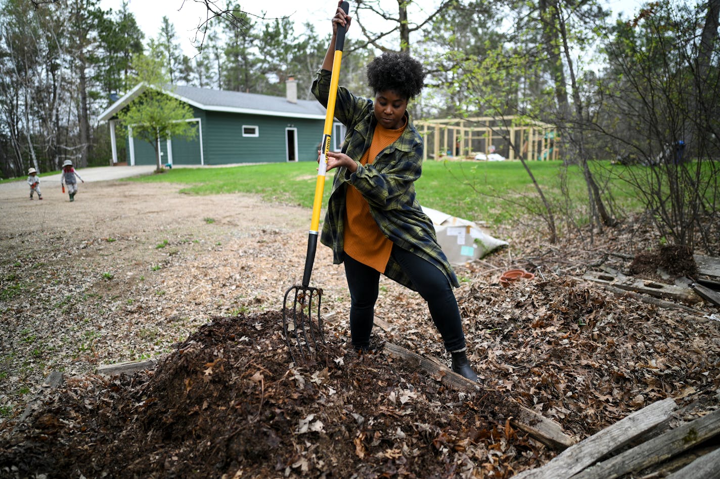 Jovan C. Speller uses a pitchfork to turn a compost pile Thursday, May 19, 2022 in Osage, Minn.. Speller moved her family and her artistic practice to the rural Park Rapids area. Her work -- including an ice greenhouse that was part of the Great Northern -- explores protecting Black lives. That's a something she's exploring in her own life with this move. ]   Aaron Lavinsky • aaron.lavinsky@startribune.com