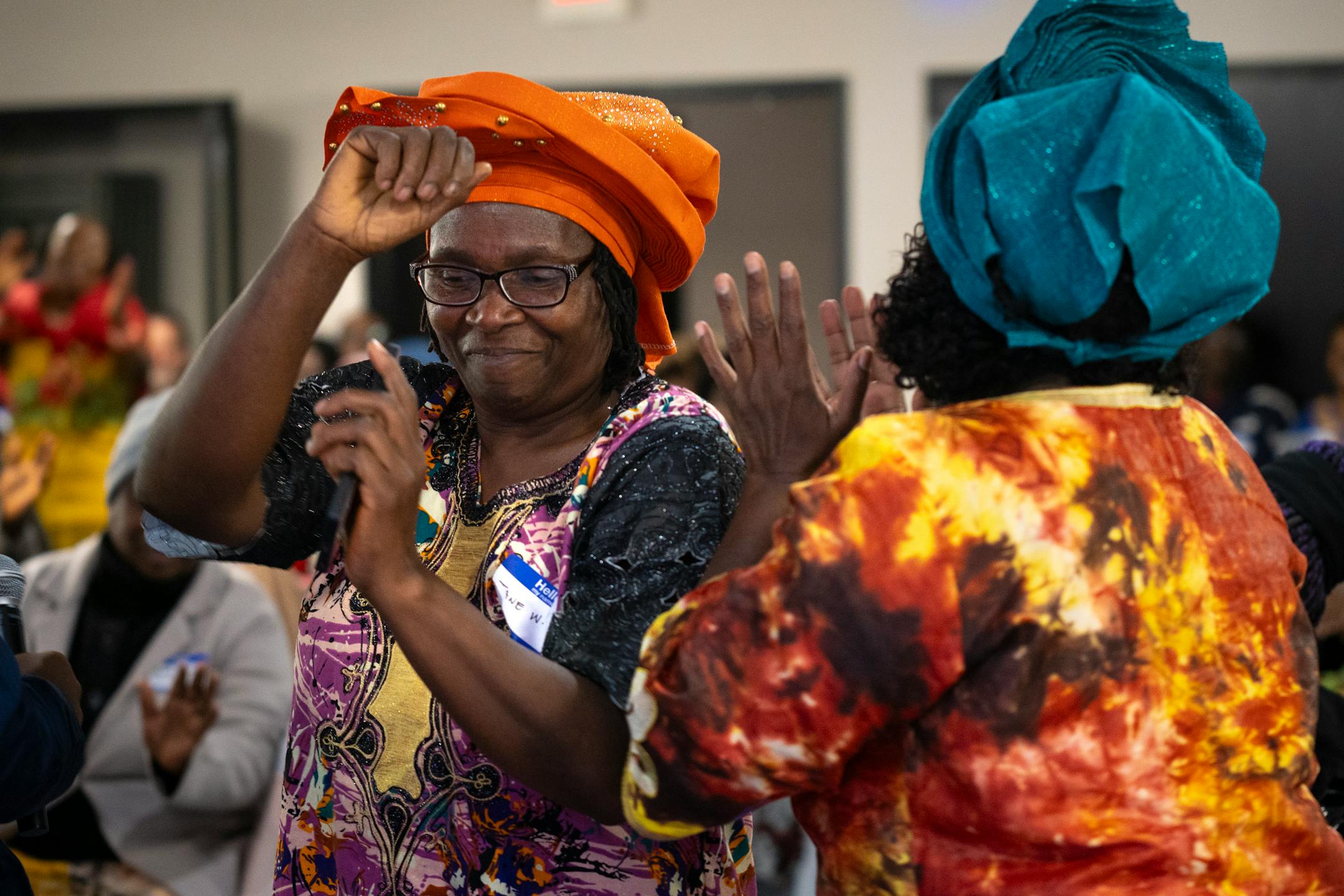 Jane Windsperger dances toward the podium after her introduction at the end-of-season harvest festival hosted by the Minnesota African Immigrant Farmer Association (MAIFA) in Maple Grove, Minn. on Sunday, Dec. 3, 2023. This is MAIFA's first annual harvest festival celebrating emerging, first-generation, and African farmers bringing Africa's diverse vegetables and crops to Minnesota. Farmers from across Minnesota and from a variety of countries in Africa brought their freshly-farmed food to the table. ] Angelina Katsanis • angelina.katsanis@startribune.com