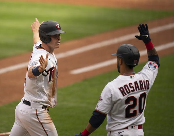 Minnesota Twins right fielder Max Kepler (26) was congratulated by left fielder Eddie Rosario (20) after he scored in the third inning on a double by 