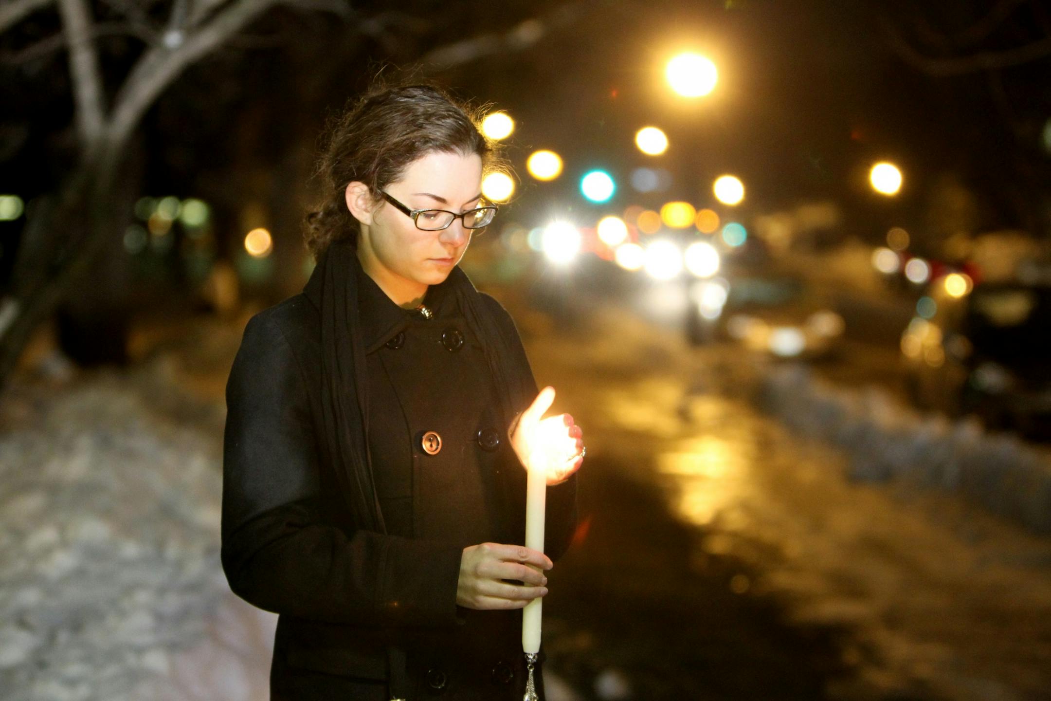 Kerri Broste lights a candle during a rally against gun violence in Minneapolis on Dec. 14, 2012.