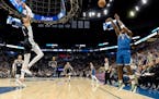 Minnesota Timberwolves guard Anthony Edwards (5) makes a three pointer while defended by Victor Wembanyama (1) of the San Antonio Spurs in the third q