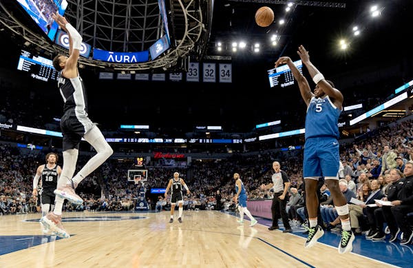 Timberwolves guard Anthony Edwards made a three-pointer while defended by the Spurs' Victor Wembanyama in the third quarter Tuesday night.