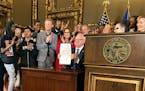 Minnesota Democratic Gov. Tim Walz beams on Friday, May 5, 2023, in St. Paul, Minn., after signing the “Democracy for the People Act,” which aims 