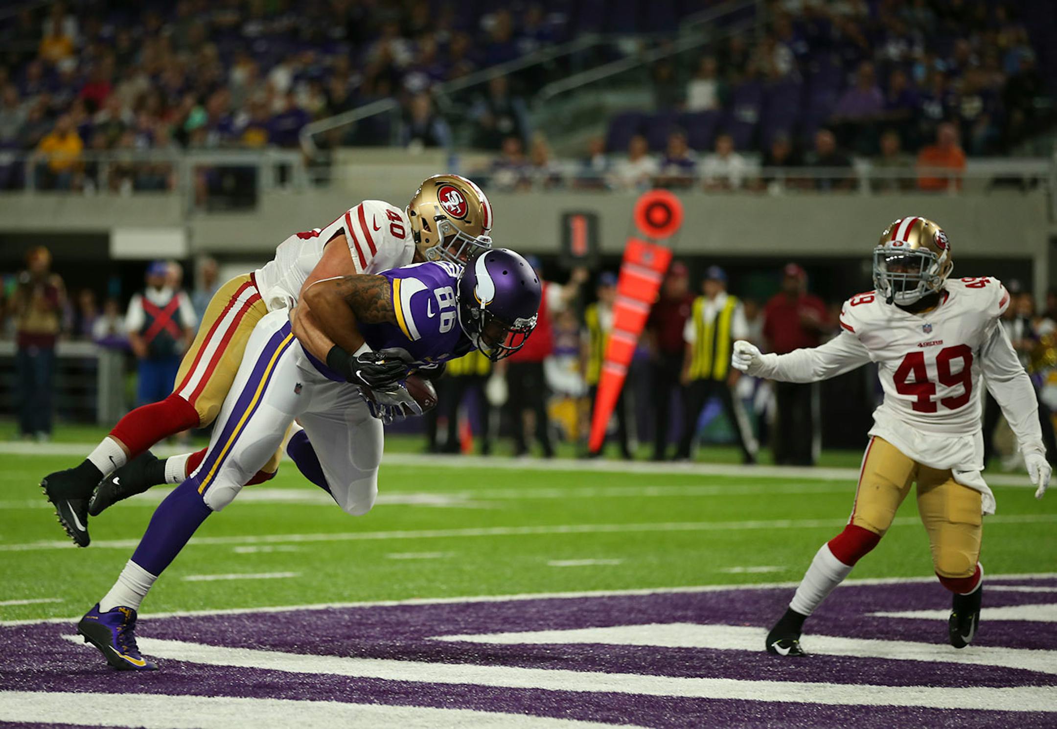 Minnesota Vikings tight end Kyle Carter (86) was tackled in the end zone by San Francisco 49ers defensive back Vinnie Sunseri (40) after a 16 yard reception.
