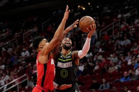 Minnesota Timberwolves' D'Angelo Russell (0) shoots as Houston Rockets' KJ Martin defends during the first half of an NBA basketball game Sunday, Jan.