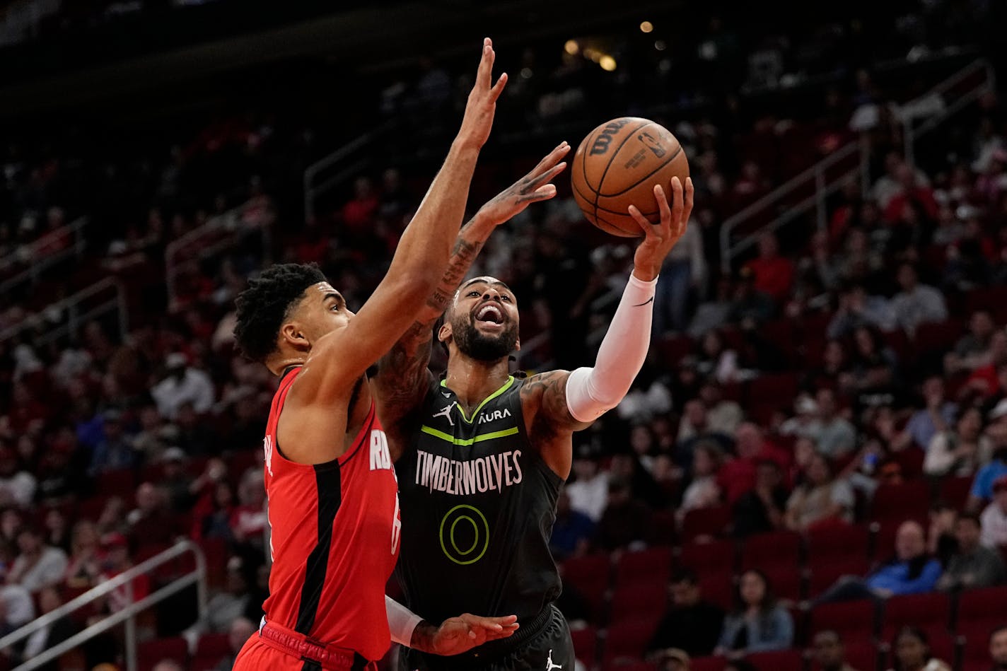 Minnesota Timberwolves' D'Angelo Russell (0) shoots as Houston Rockets' KJ Martin defends during the first half of an NBA basketball game Sunday, Jan. 8, 2023, in Houston. (AP Photo/David J. Phillip)