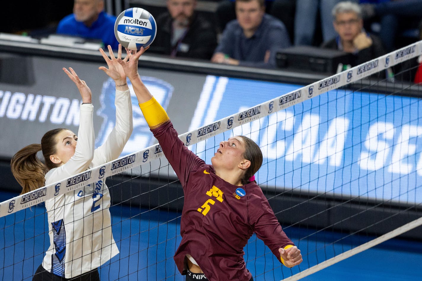 Minnesota's Melani Shaffmaster tapped the ball over the net toward Creighton's Norah Sis during the third set of Saturday's NCAA women's volleyball tournament match in Omaha