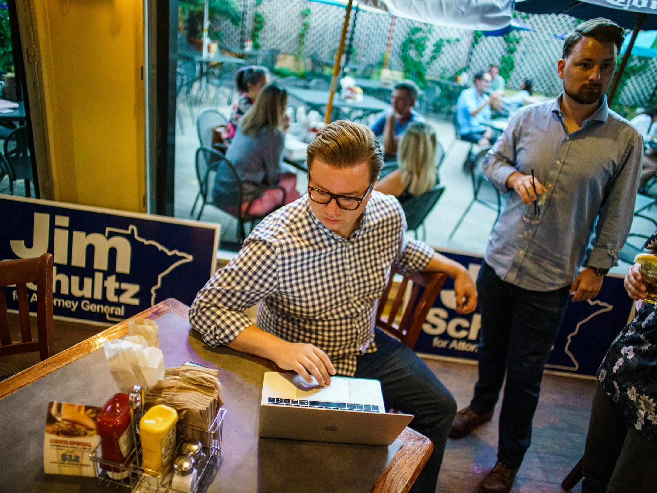 Volunteer Peter Glessing tracks results for Jim Schultz as supporter Micah Olson stand by during primary election night for GOP attorney general candidate Jim Schultz at Moe's Burger in St. Paul.