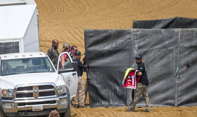 A track worker carries the saddle blanket of Havnameltdown away as the horse is euthanized after suffering a leg injury during the sixth race prior to