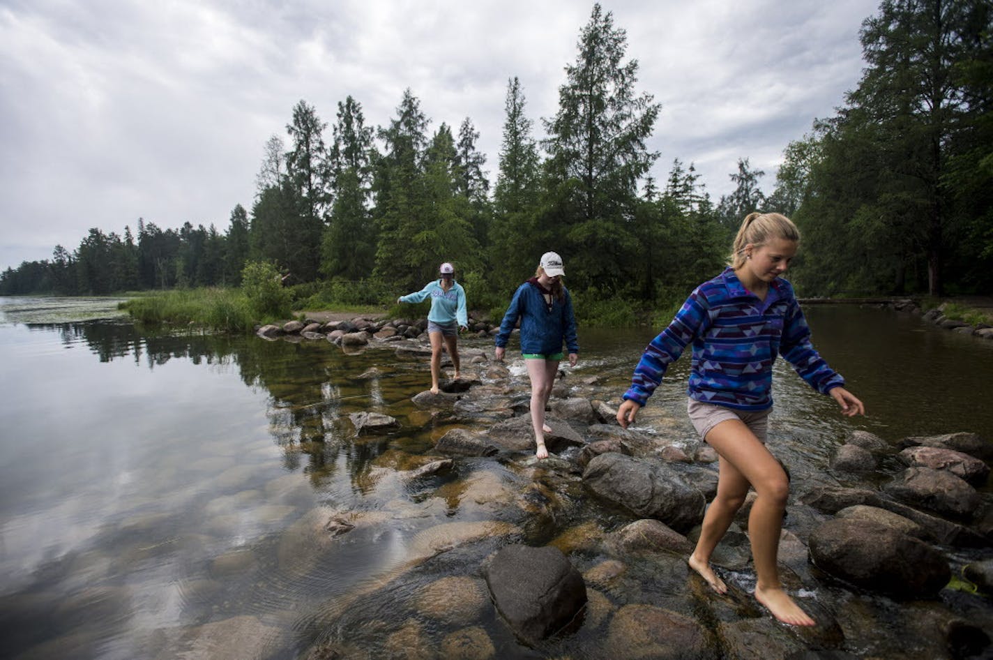 Emma Daniels, right, Abby MacFarlane and Marie Preston, back, walked across the rocks at the headwaters of the Mississippi at Lake Itasca in mid June. The high school seniors were visiting from Fergus Falls. ] (AARON LAVINSKY/STAR TRIBUNE) aaron.lavinsky@startribune.com RIVERS PROJECT: We look at three of Minnesota's rivers, including the Mississippi, Red and Chippewa, to see how land use effects water quality and pollution.