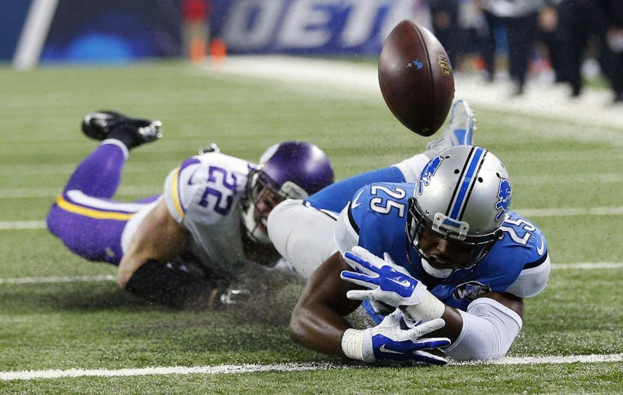 Detroit Lions running back Theo Riddick (25) loses control of the ball at the goal line after being tackled by Minnesota Vikings free safety Harrison Smith (22) during the first half of an NFL football game, Sunday, Oct. 25, 2015, in Detroit.
