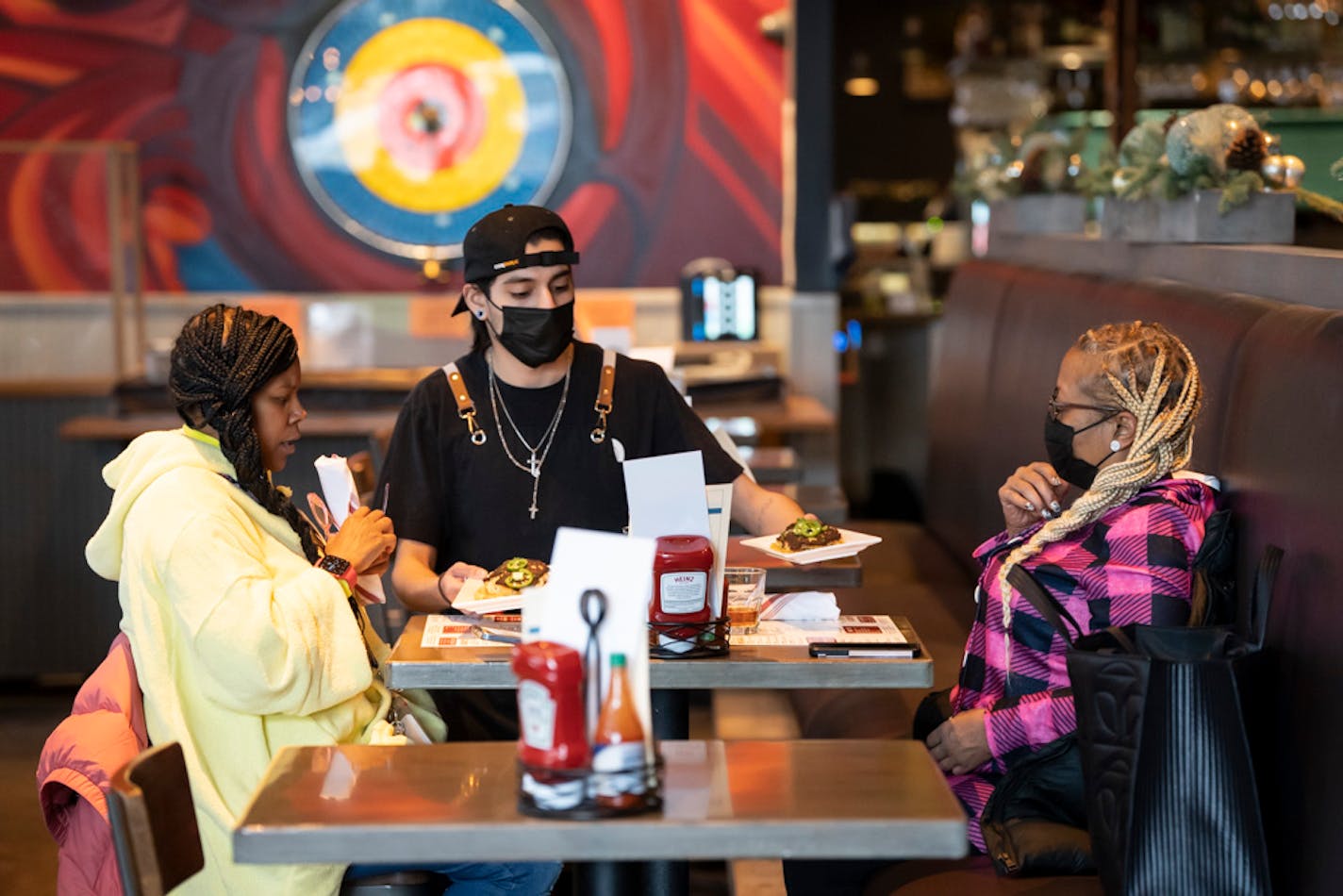 Server Luis Gonzalez brings friends Jasheena Bond and Erica Mooring their food order at the Smack Shack on Friday, Jan. 21, 2022 in Minneapolis, Minn. ] RENEE JONES SCHNEIDER • renee.jones@startribune.com