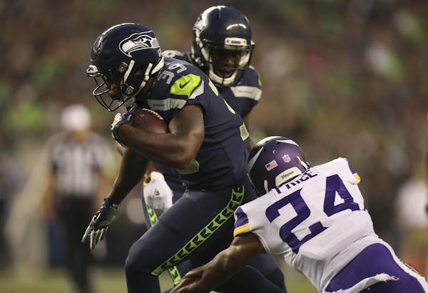 Seattle Seahawks running back Mike Davis (39) broke a tackle by Vikings cornerback Jabari Price (24) while heading for the end zone with a 22 yard tou