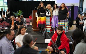 Shaneesa Scheckel, Nicole Poitra, Montana Moore and Lolita Spotted Thunder Granados, left to right, stand and listen to the White Elk Singers perform