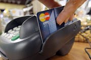 A customer swipes a MasterCard debit card through a machine while checking-out at a shop in Seattle.