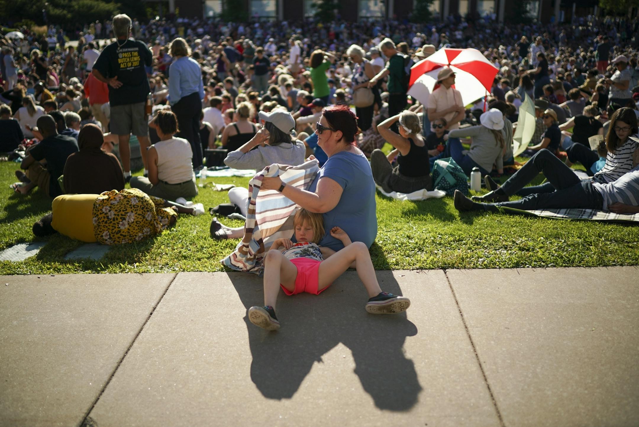 Angel Woehler shielded her daughter, Avalon, 7, from teh sun while waiting for the Town Hall to begin.