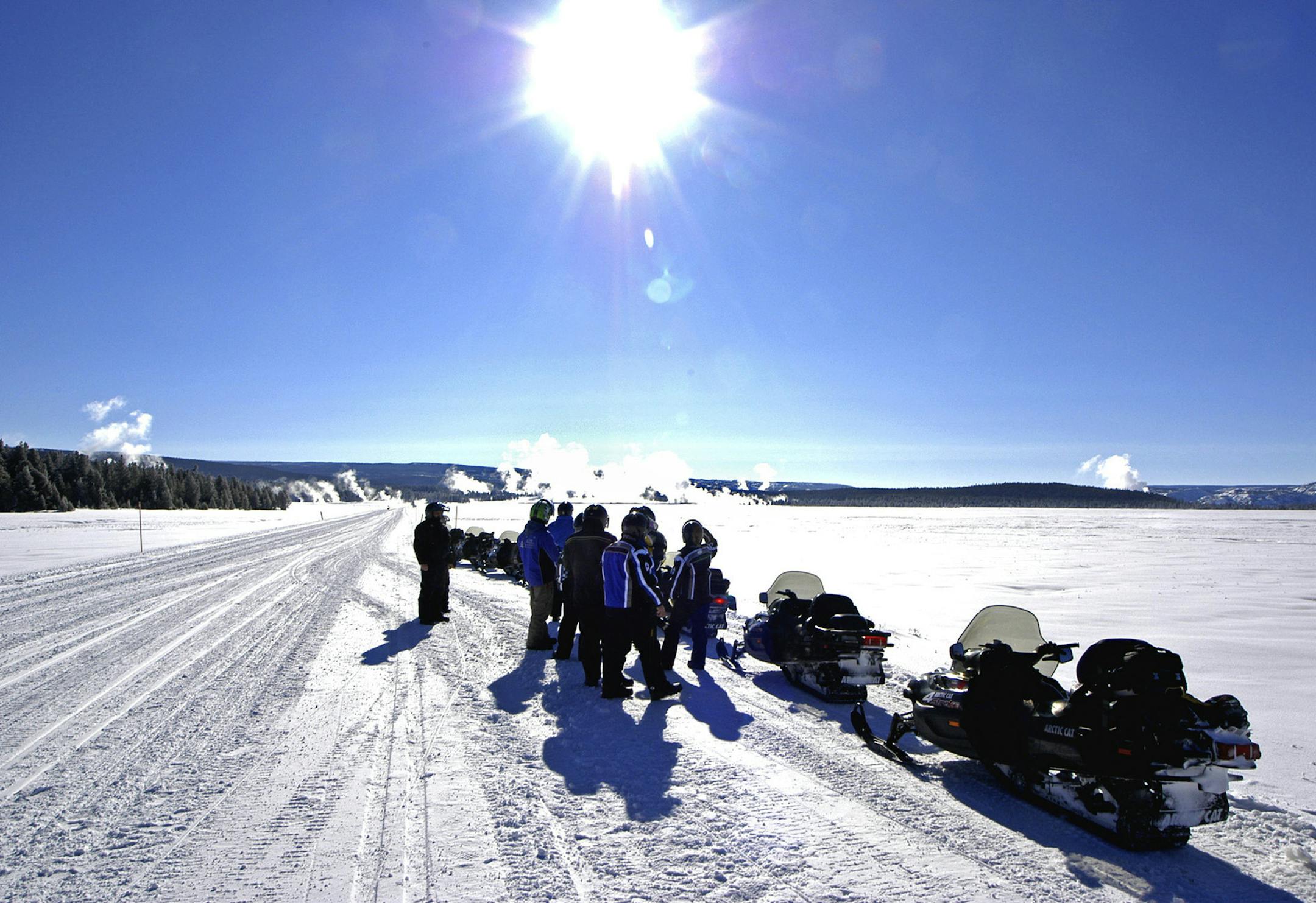 Snowmobilers on a day trip inside Yellowstone National Park pause to view distant geysers and the Yellowstone caldera while en route to Old Faithful. Snowmobilers must use rented four-stroke sleds to reduce pollution, and must be guided. (Dennis Anderson/Minneapolis Star Tribune/MCT)