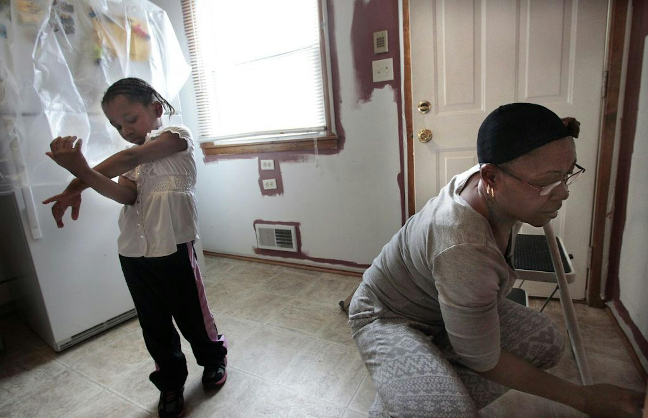 Homeowner Deann Gayles painted her kitchen with a little help from granddaughter Eryca Walker, 5.