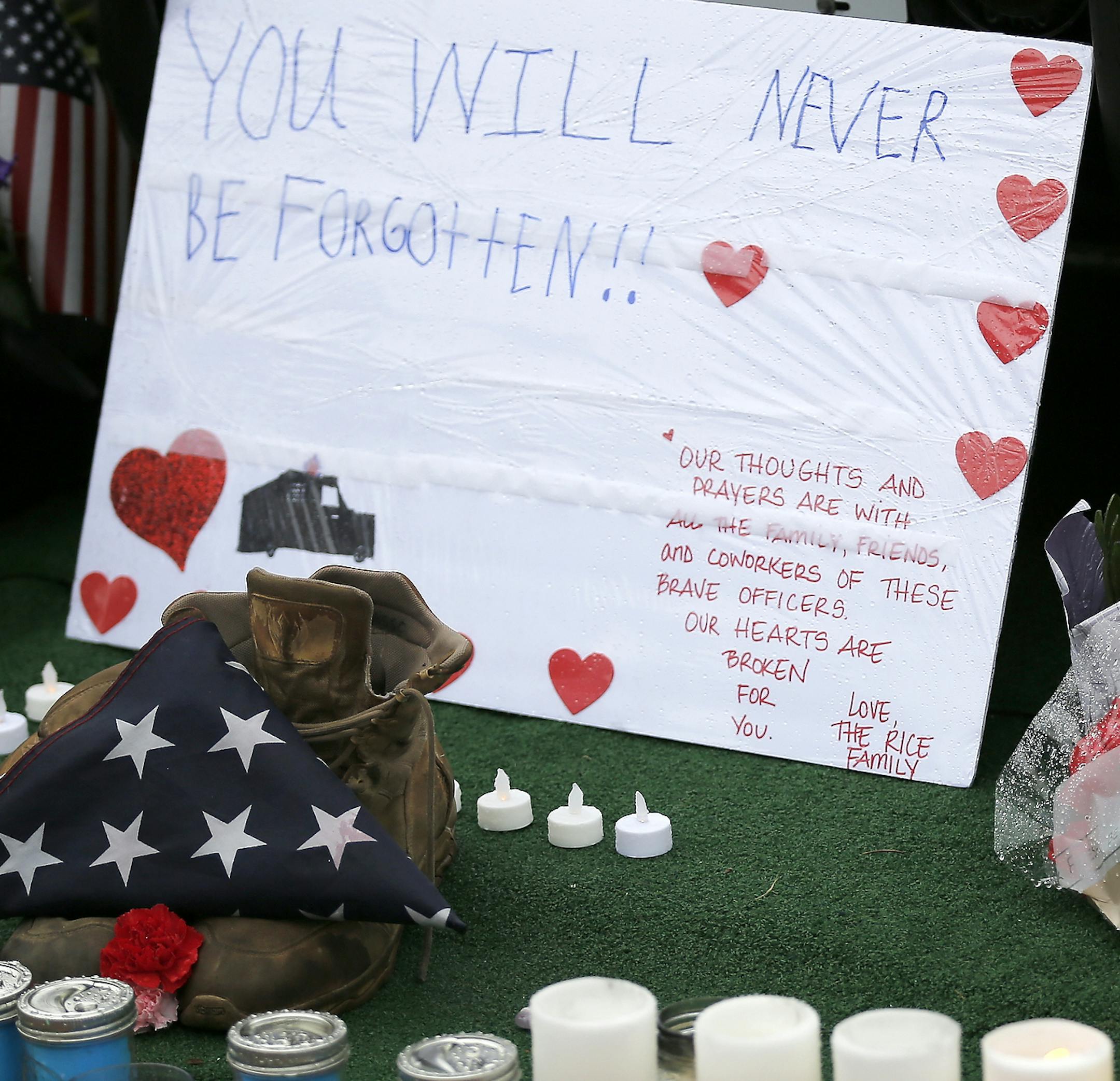 Mourners gather and leave flowers on a police cruiser parked in front of City Hall in Westerville, Ohio, on Sunday, Feb. 11, 2018. Westerville police officers Anthony Morelli and Eric Joering were killed in the line of duty Saturday when a suspect opened fire on them as they responded to a call at a residence.(Sam Greene/The Cincinnati Enquirer via AP)