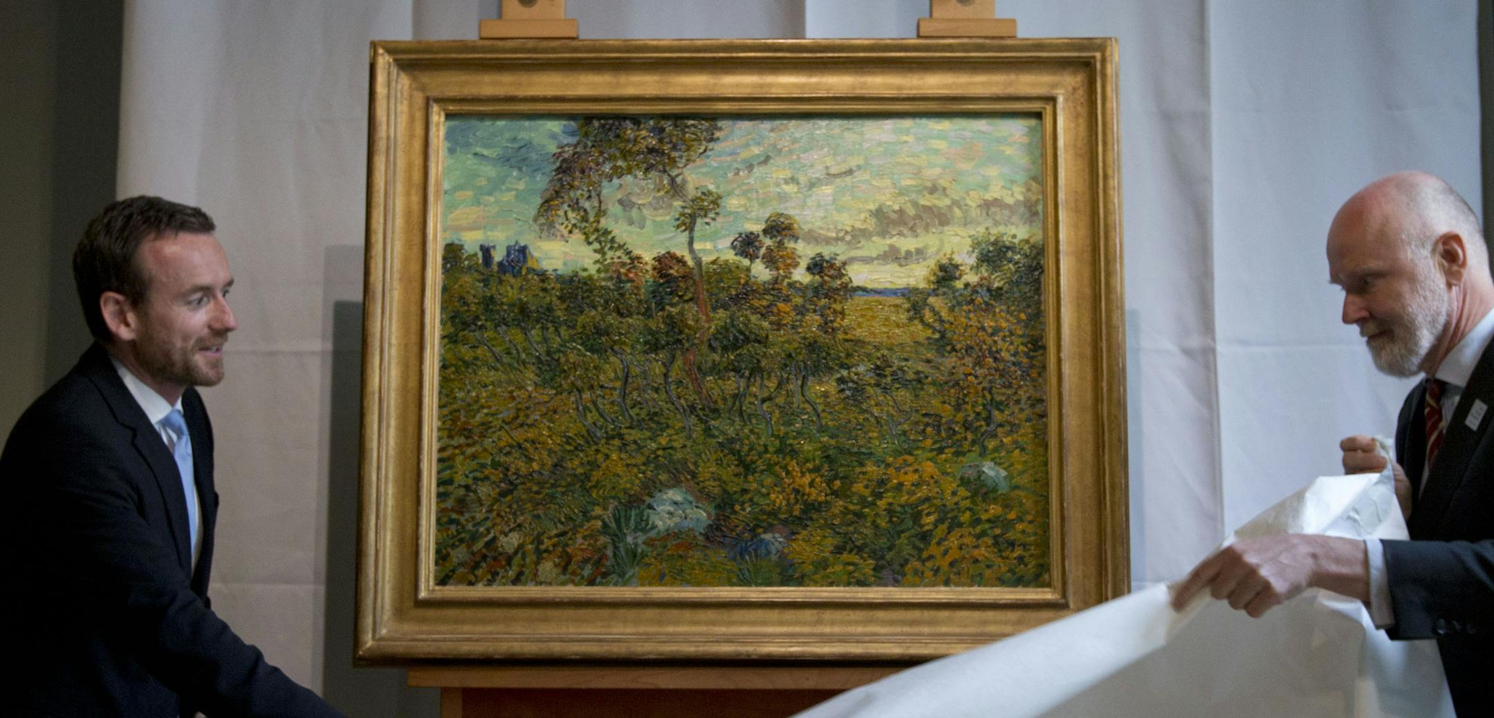 Van Gogh Museum director Axel Ruger, left, and senior researcher Louis van Tilborgh, right, unveil "Sunset at Montmajour" during a press conference at the Van Gogh Museum in Amsterdam, Netherlands, Monday.