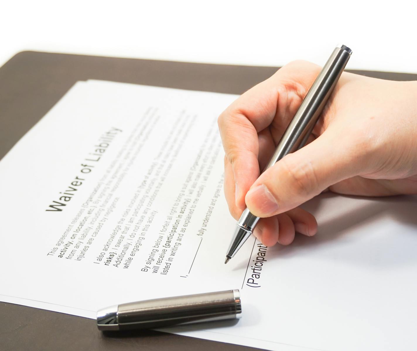 Hand of a businessman signing a waiver form