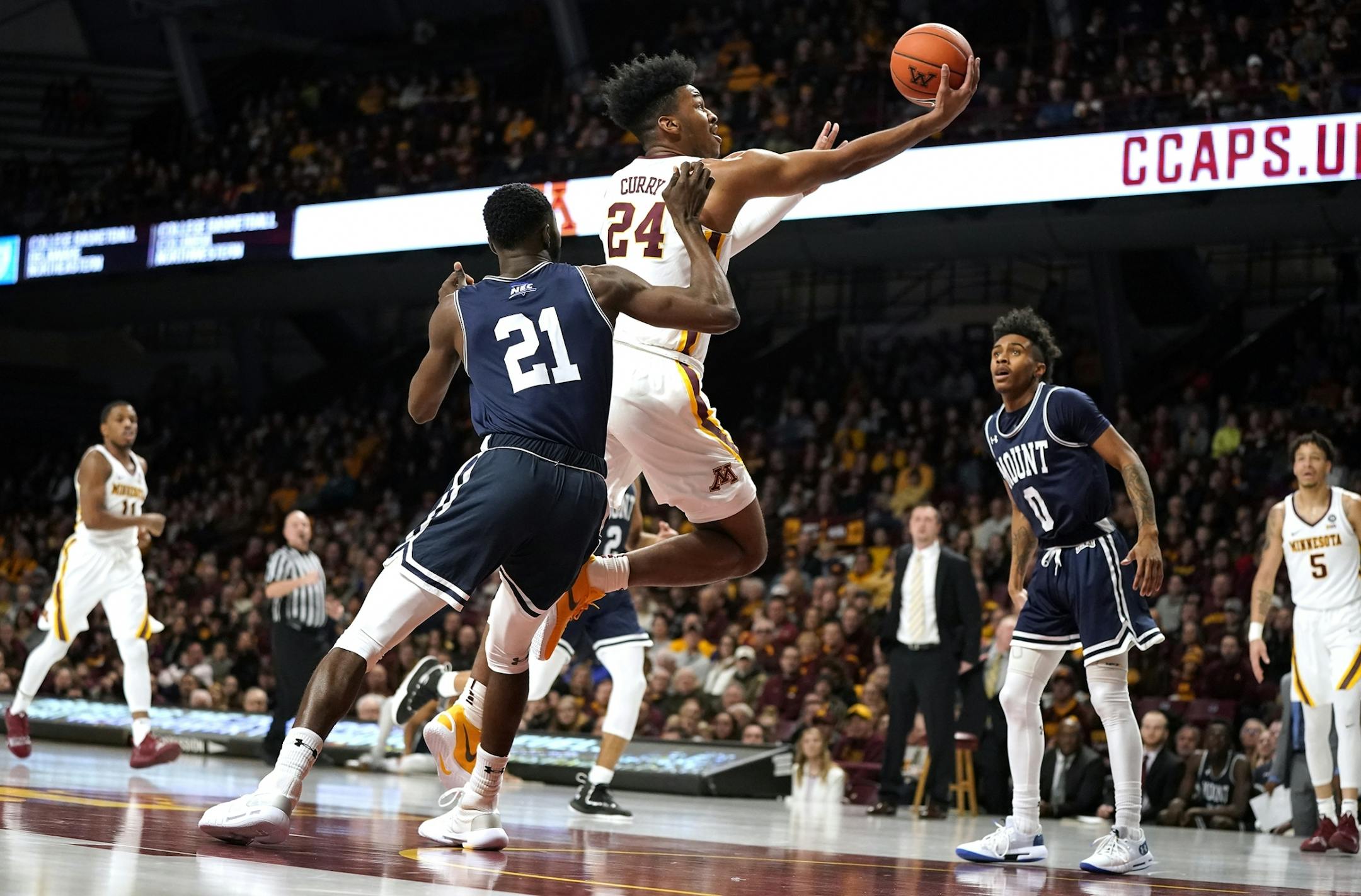 Minnesota forward Eric Curry (24) shoots as Mount St. Mary's forward Collin Nnamene (21) defends during the first half.