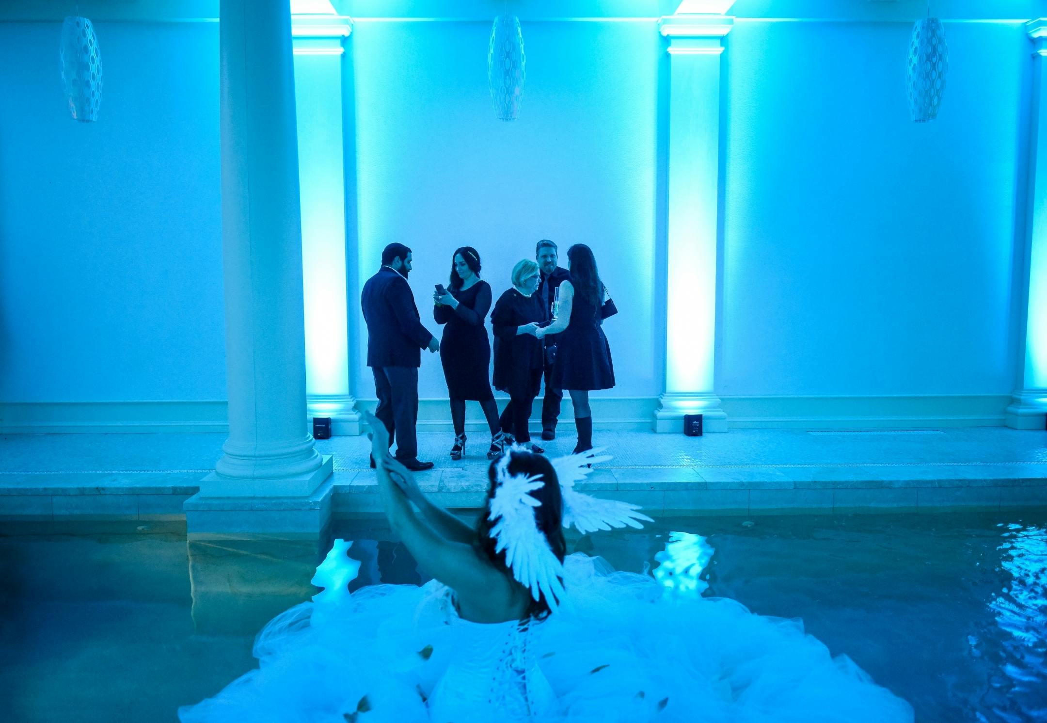 Party goers looked on as a performer with Elan Artists, dressed as a swan and in an indoor pool, floated about during Saturday night's "Big Game Big Give" party in Edina.