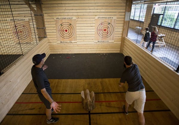 (Left) Mike Dufresne and Jason Kimmel go toe to toe in an axe throwing game.